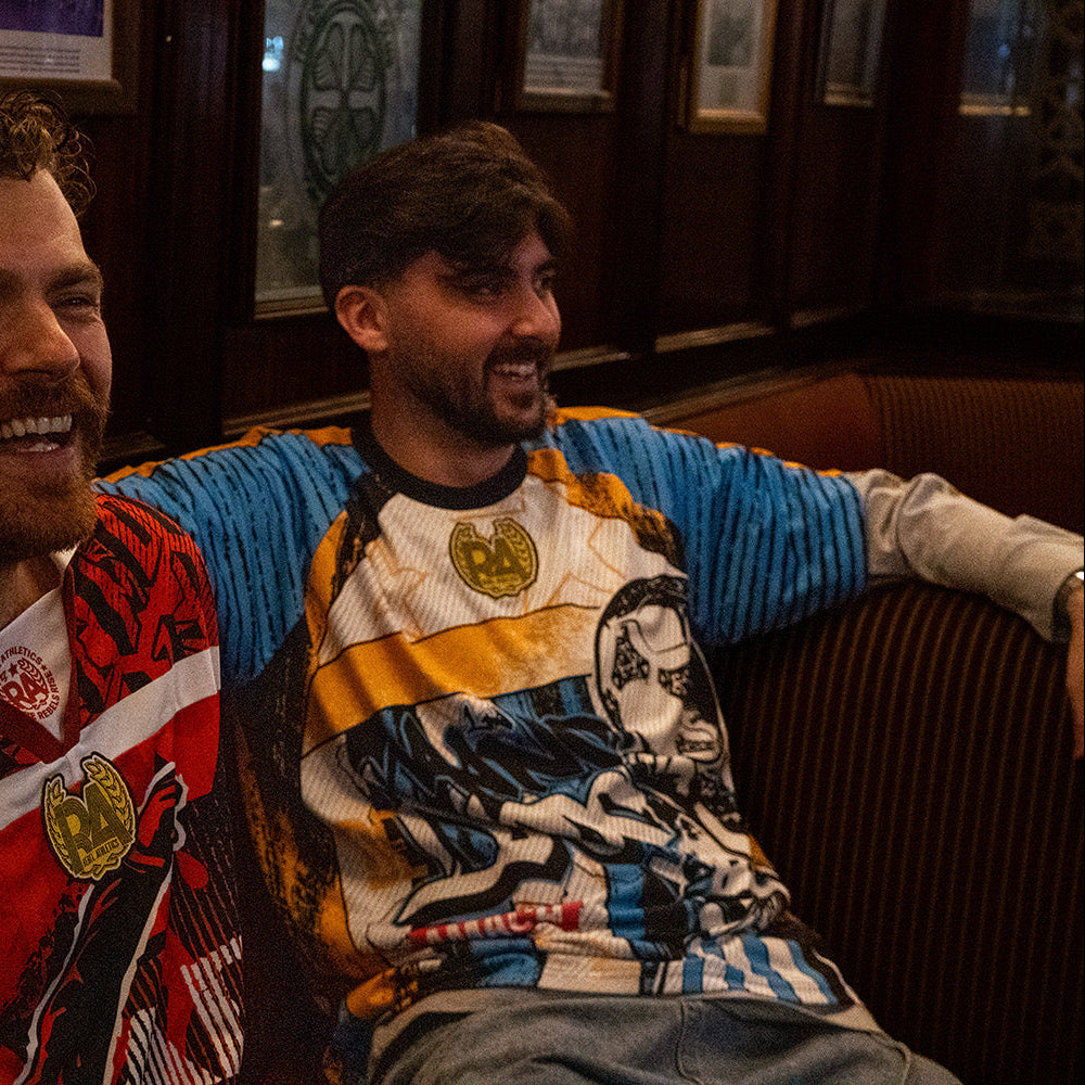 AMACH Rebel Athletics Maradona jersey, blue, white and yellow 90s-style football shirt, worn in a bar