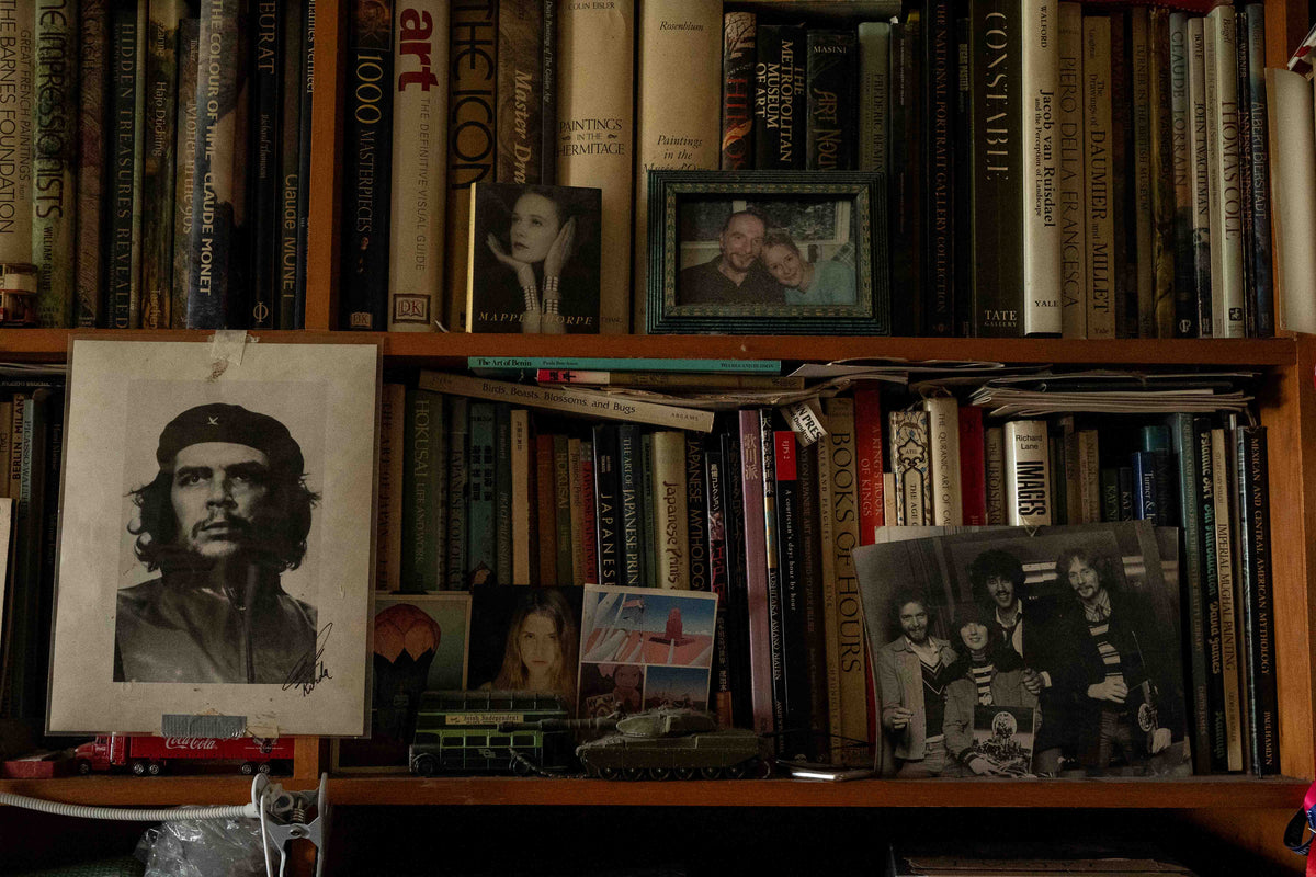 Bookshelves and a framed Che Guevara portrait, from the AMACH By Any Means campaign