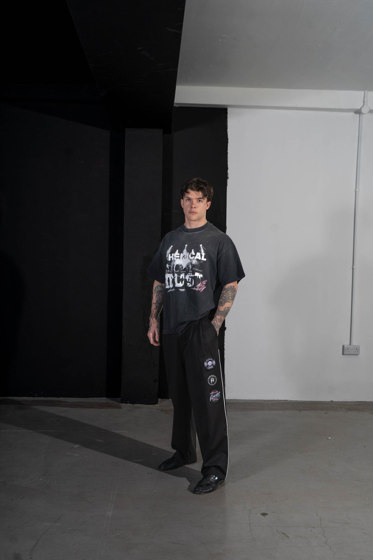 Model wearing the AMACH Chemical Dust t-shirt with Euphoric Love slacks in the studio
