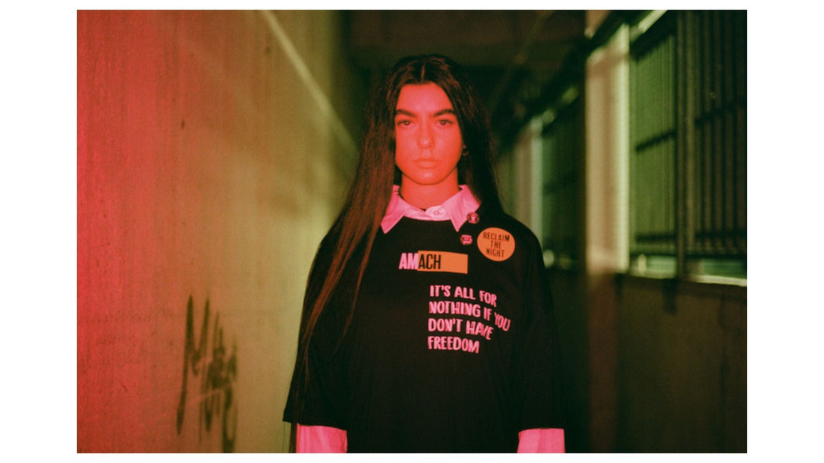 AMACH graphic tee from a collaboration, worn in a red-lit corridor