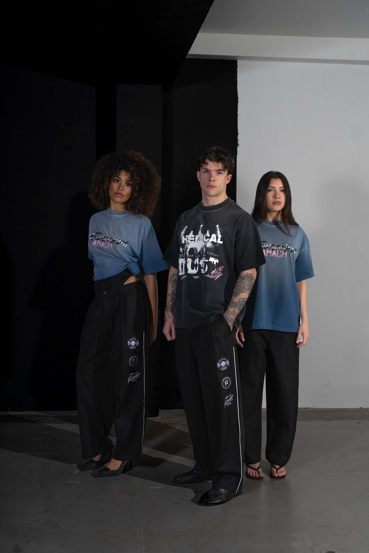 Three models in AMACH Euphoric Love tees and slacks, centre model in the Chemical Dust t-shirt