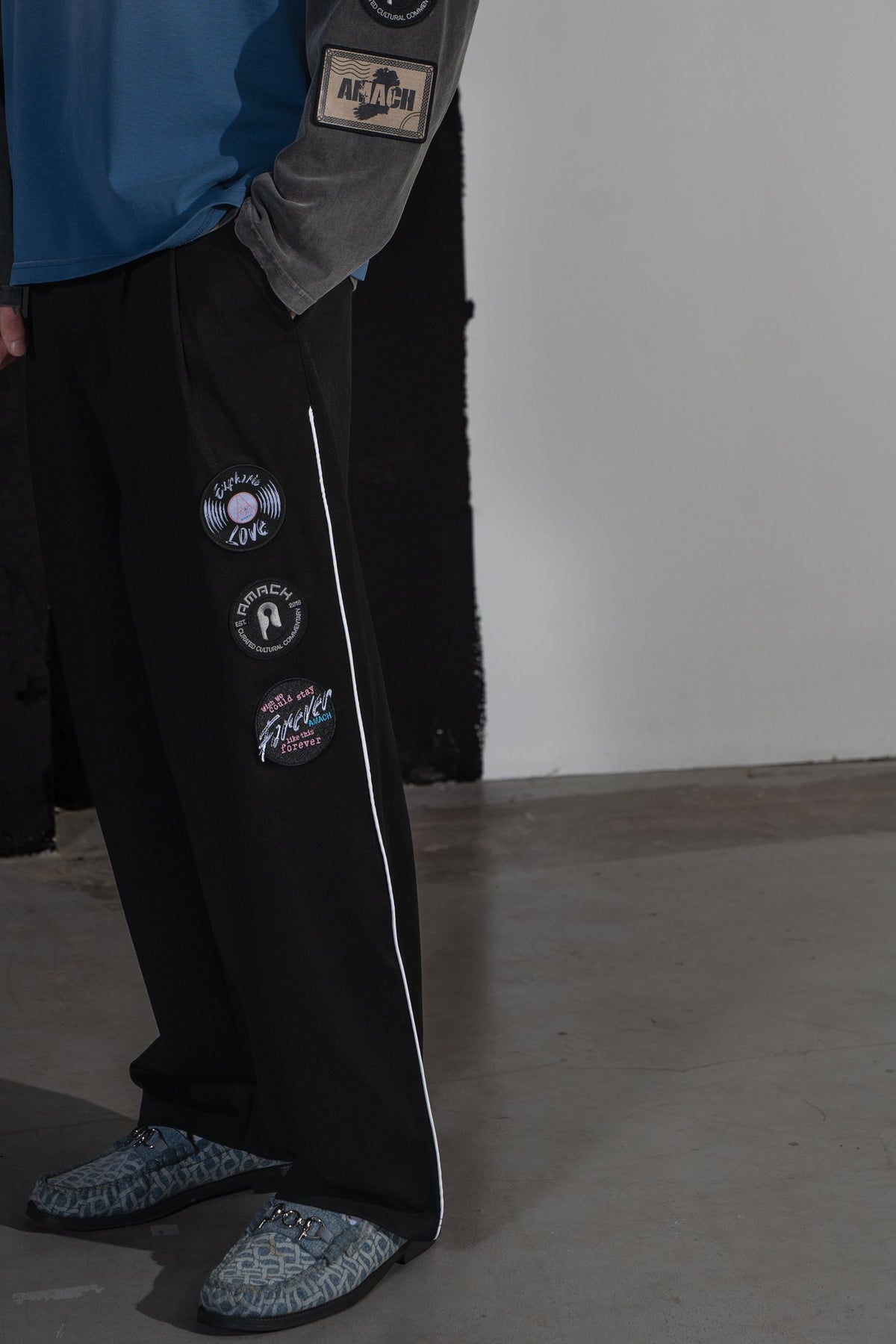 Close-up of the embroidered patches and woven record patch on AMACH Euphoric Love slacks